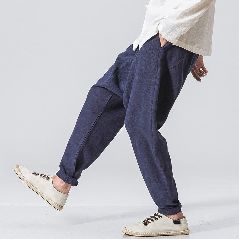 Men’s black loose drop-crotch harem pants with relaxed fit and cuffed ankles. 