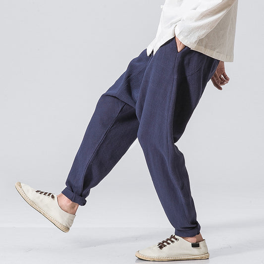 Men’s black loose drop-crotch harem pants with relaxed fit and cuffed ankles. 