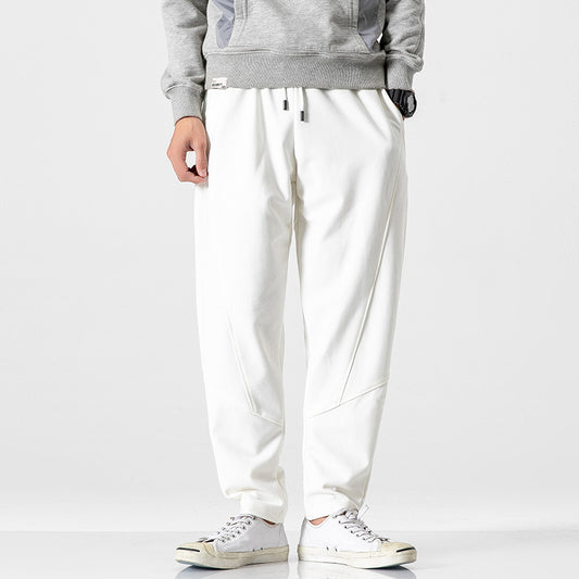 Man wearing white jogger pants and grey hoodie, streetwear fashion by Threadspired