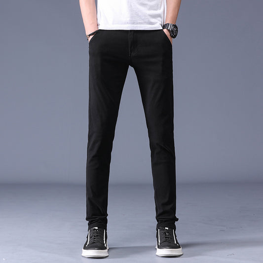 Men’s black slim fit casual pants worn with sneakers and a white T-shirt against a neutral background. 