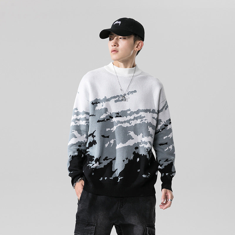 Man wearing a white to grey to black gradient knit crewneck sweater with camo-style graphic pattern.