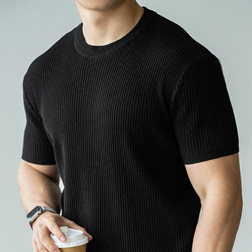 Man wearing a black ribbed short sleeve crew neck t-shirt. 
men’s t-shirt, short sleeve men’s shirt, crew neck tee, men’s slim fit t-shirt, black t-shirt, men’s casual top, 
minimalist men’s clothing, summer men’s top, casual men’s wear