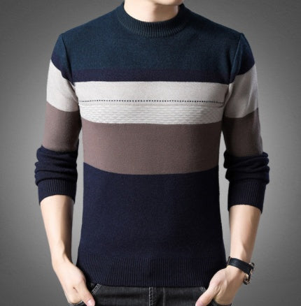 Man wearing a navy, grey and beige colorblock striped ribbed knit crewneck sweater with long sleeves. 
