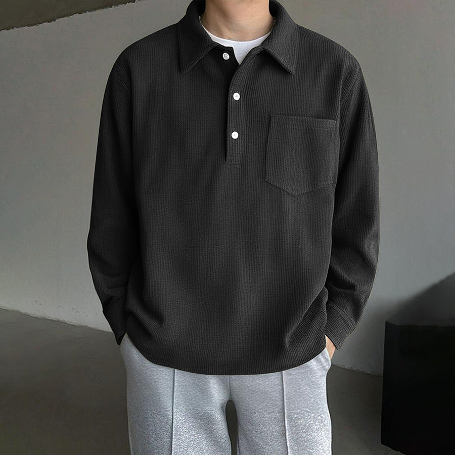 Black men’s long sleeve corduroy polo shirt with button collar and chest pocket on white background. 