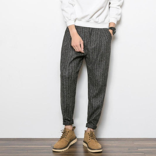 Man wearing charcoal grey slim tapered casual pants with textured fabric, styled with a sweatshirt and 
boots. 