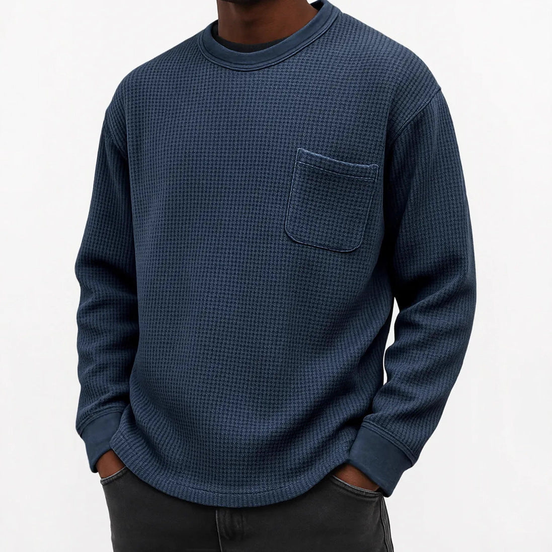 Man wearing a blue waffle knit long sleeve crew neck shirt with a chest pocket. 