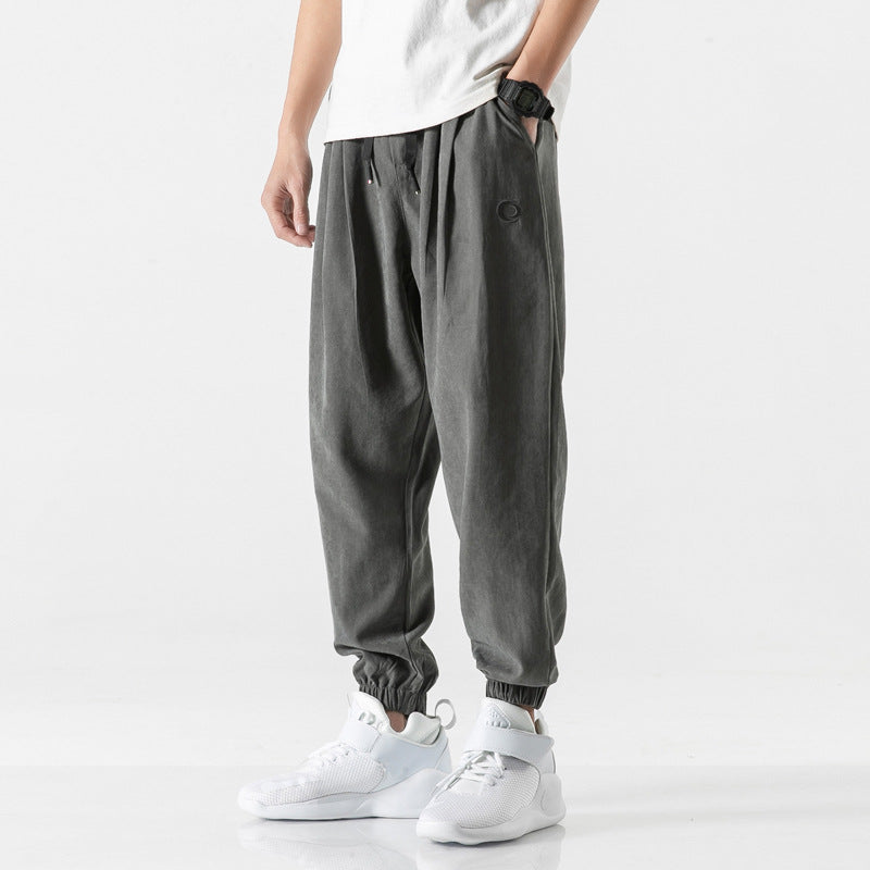 Man wearing relaxed fit gray jogger sweatpants with elastic cuffs and drawstring waist.