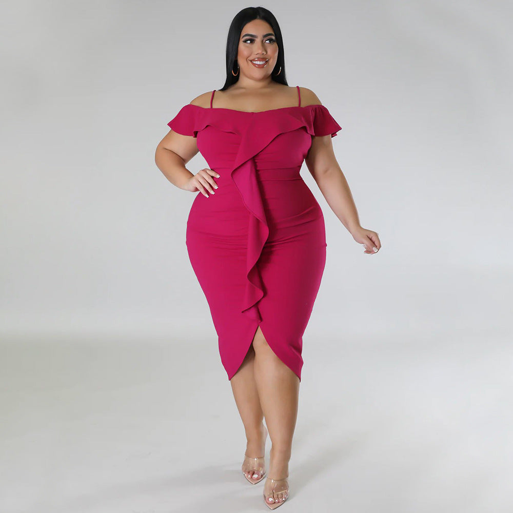 Plus size woman wearing a black off-shoulder (with slim straps) bodycon midi dress with ruffle front detail 
and front slit, styled with heels and gold accessories. 