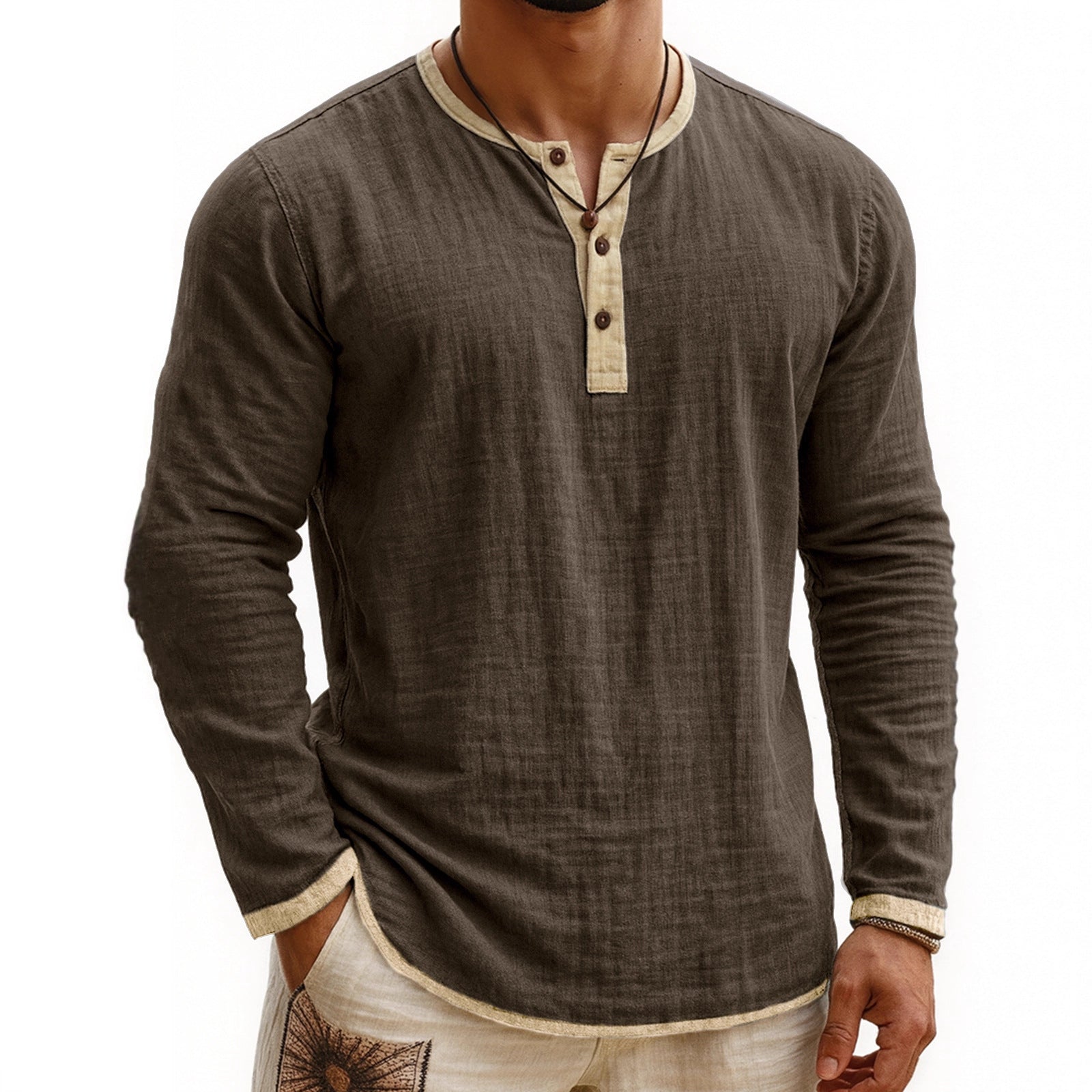 Man wearing a light blue long sleeve linen Henley shirt with contrast button collar. 