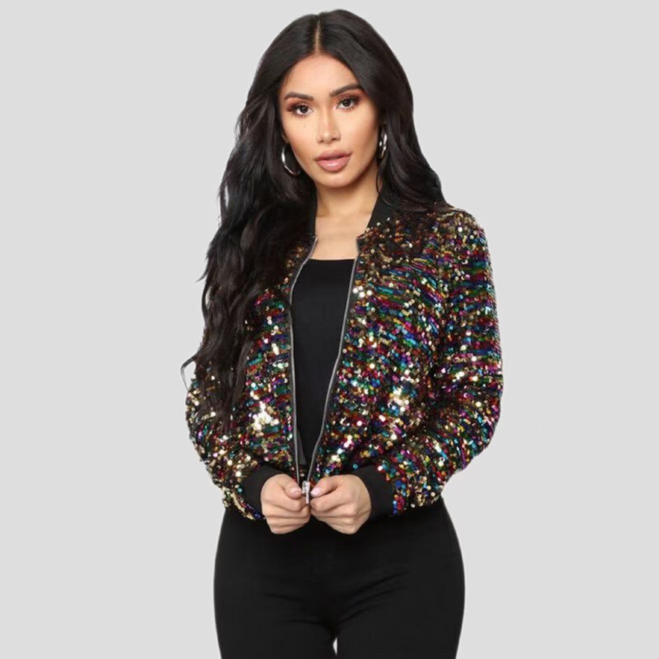Woman wearing a multicolor sequin zip-up long sleeve jacket over a black outfit.