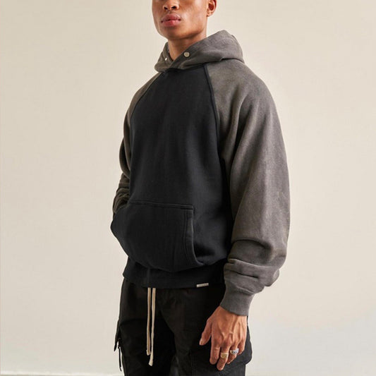 Cream and black color block hoodie with raglan sleeves and a front pouch pocket, displayed against a white 
background.