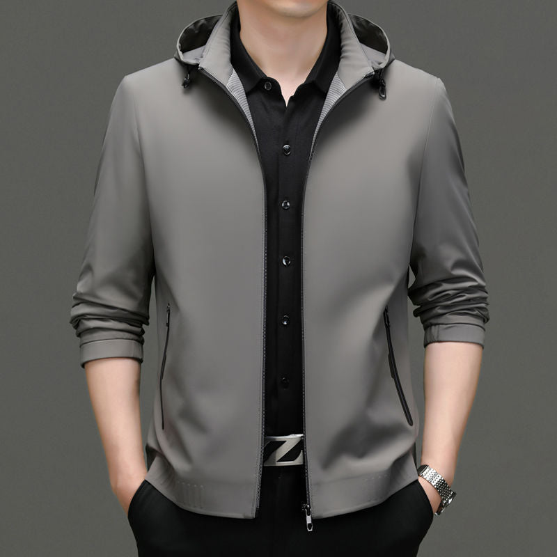 Man wearing a black hooded zip-up jacket over a white t-shirt.